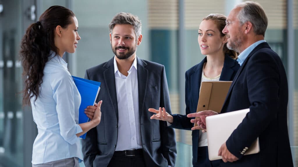 Account executives having a discussion in office corridor